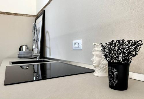 a bathroom with a mirror and a vase with a plant at Design Suite 38 Noto in Noto
