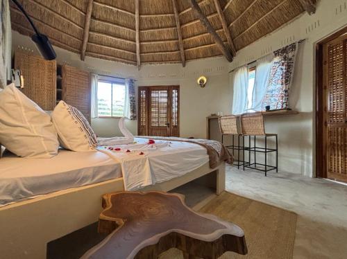 a bedroom with a large bed in a room with windows at Basecamp Changani in Dar es Salaam