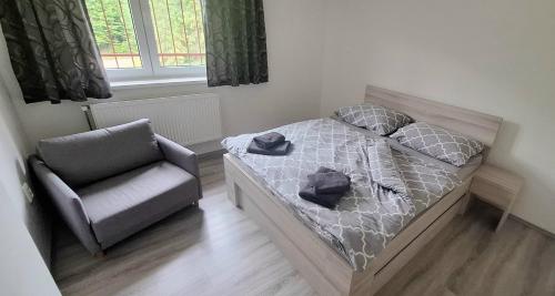 a small bedroom with a bed and a chair at Chata LANOVKA - Vojtechova samota in Spišská Nová Ves