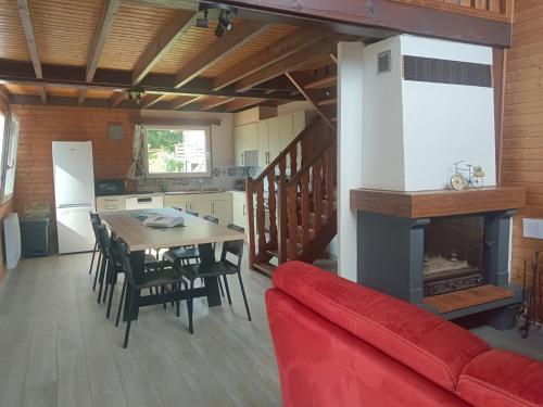 salon ze stołem i kominkiem w obiekcie Chalet idéal 4-8 pers avec garage 20 mn Gérardmer w mieście Vienville