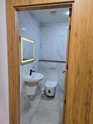 a white bathroom with a sink and a toilet at Luxury appartment avec piscine à la Marina Saidia in Saidia 