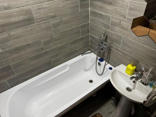 a bathroom with a white tub and a sink at Квартира с видом на Усть-Каменогорск in Ustʼ-Kamenogorsk