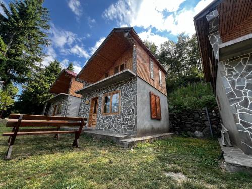 a small stone house with a bench in front of it at Resort Komovi in Kravlja