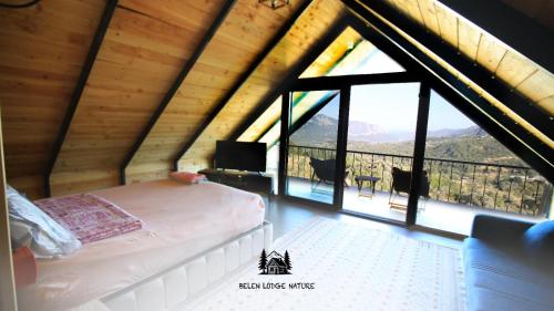 a bedroom with a bed and a large window at Belen nature&lodge in Kumluca