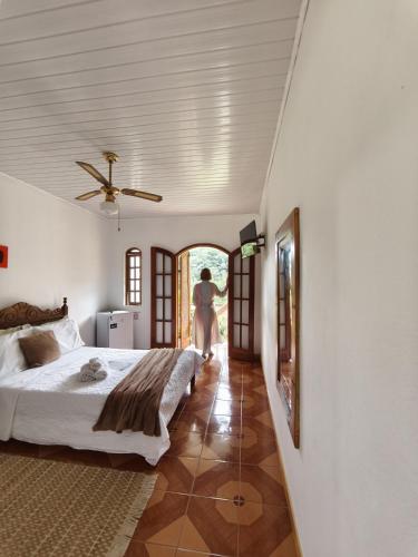 a woman walking into a bedroom with a bed at Villa Toca da Toca Lumiar in Nova Friburgo
