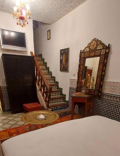 a room with a staircase with a mirror and a bed at Palais AL Firdaous in Fès