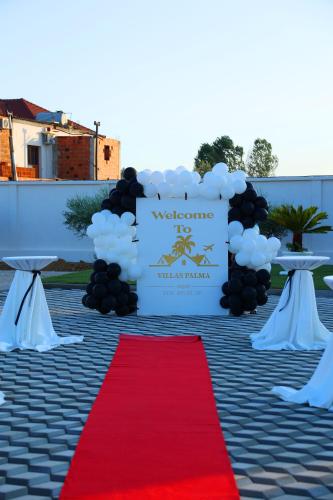 a welcome sign with a red carpet and a sign with clouds at Villas Palma Airport in Rinas