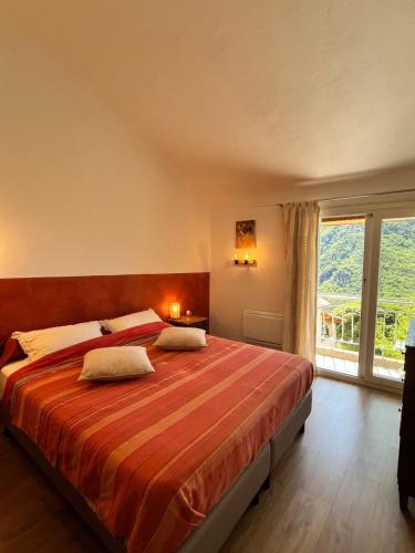 a bedroom with a large bed with a large window at La maison colimaçon in Clans