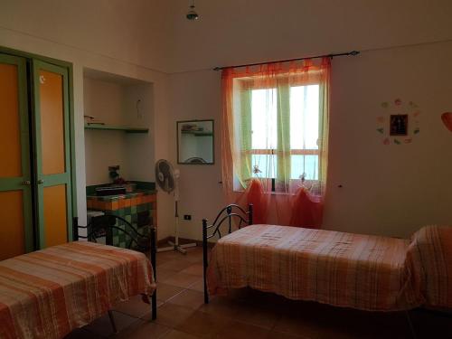 Una habitación con dos camas y una ventana. en Dammuso Specchio di Vener, en Pantelleria