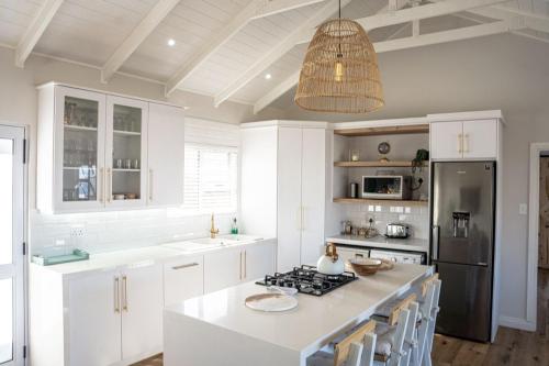 a kitchen with white cabinets and a black refrigerator at Sea and Mountain View in Mossel Bay
