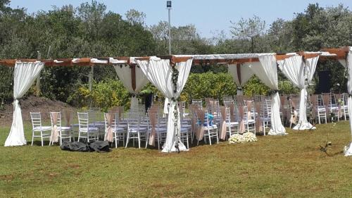 a row of chairs and tables and white curtains at The Nelion in Naro Moru