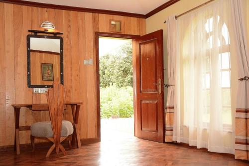 a room with a door and a table and a mirror at The Nelion in Naro Moru
