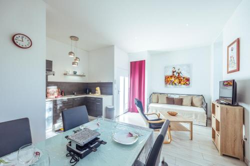a living room with a dining table and a kitchen at Le Roussel in Ax-les-Thermes