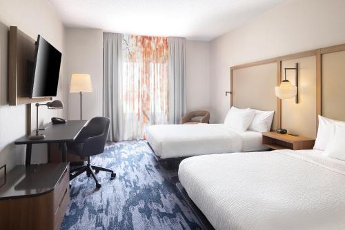 a hotel room with two beds and a desk at Fairfield Inn & Suites – Buffalo Airport in Cheektowaga