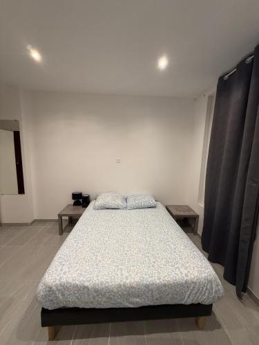une chambre blanche avec un lit et deux tables dans l'établissement Appartement Tour Eiffel Motte Picquet Fondary, à Paris