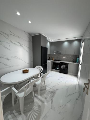 a kitchen with a white table and white chairs at Marina Smir Apartment in Marina Smir