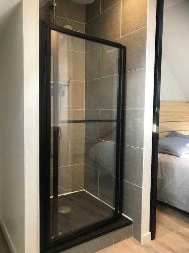 - une douche avec une porte en verre dans la chambre dans l'établissement Villa Fouesnant Beg Meil Ty Bigorn 150 m plage et sentiers, à Fouesnant