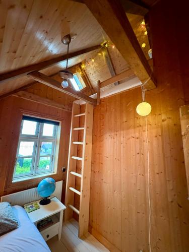 a room with a ladder and a bed and a window at Cozy Holiday Home in Sandavágur