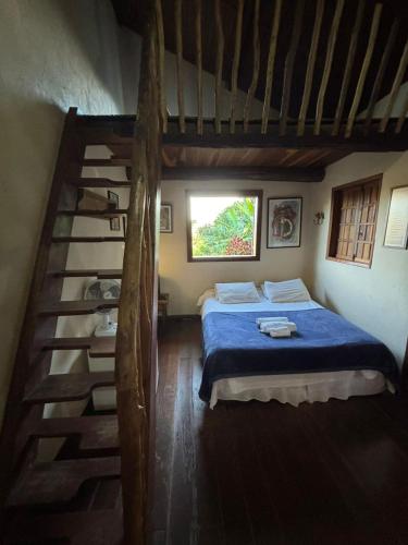 a bedroom with a blue bed and a staircase at Capricho Asturiano in Santo Antônio do Leite