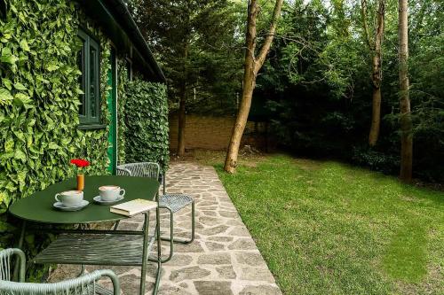a green table with a flower on it in a yard at Restful Break 2 BR Woods Cottage 2 Acre Garden gated free Parking in Chislehurst