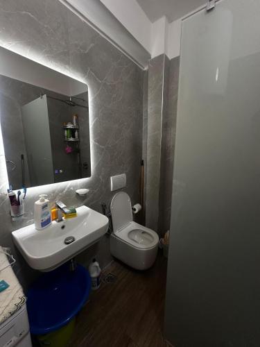 un baño con lavabo, inodoro y espejo en Valona2025, en Vlorë