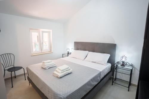 a bedroom with a bed with two towels on it at Domus Picena - Suites & Relax in Grottammare