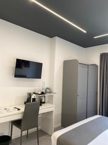 a bedroom with a bed and a desk and a tv at Empire B&B in Diamante