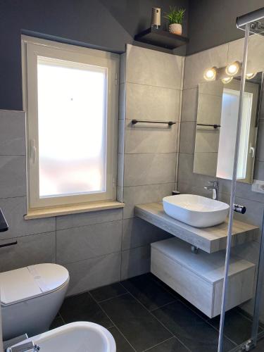 a bathroom with a sink and a toilet and a window at Empire B&B in Diamante