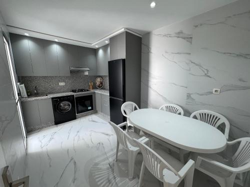 a kitchen with a white table and white chairs at Marina Smir Apartment in Marina Smir