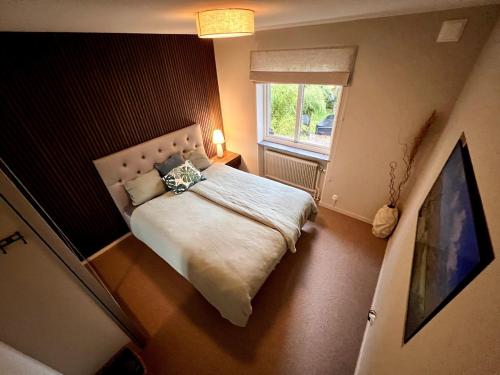 a bedroom with a bed and a window at Stylish Villa, Terrace & Garden in Ljungby