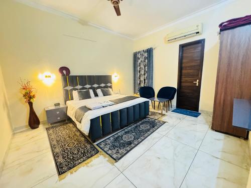a bedroom with a bed and chairs in a room at Sandhu Homestay in Sri Guru Ram Dass Jee International Airport