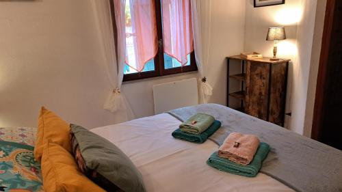a bedroom with a bed with two towels on it at L'Auberge in Saint-Martin-dʼArmagnac
