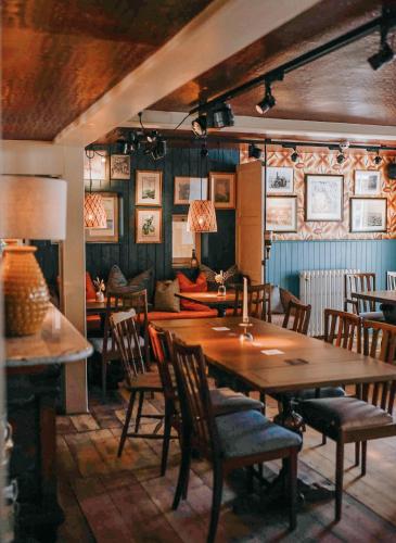 a dining room with a table and chairs and a couch at The Kings Arms Rooms in Canterbury