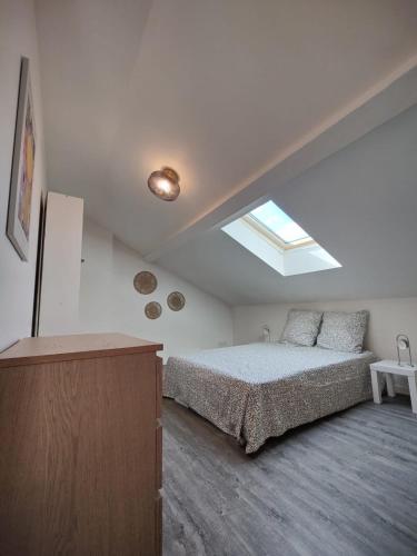 a white bedroom with a bed and a skylight at Maison de charme - Villeurbanne in Villeurbanne