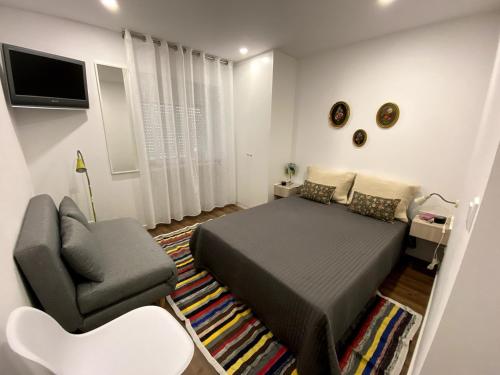 una camera da letto con un letto, un divano e una sedia di Casa da Covilhã - Pedra e Lã a Covilhã