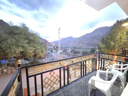 a balcony with two chairs and a view of a city at Hotel Kaza Manjushree in Kaza