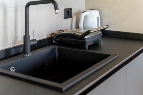 a kitchen counter with a sink next to a kitchenilit at Ollie`s house in Leivi