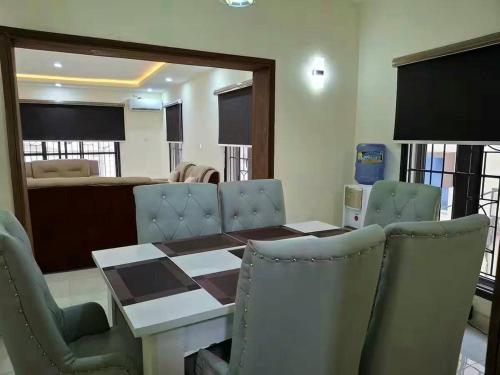 a dining room with a wooden table and chairs at Lagos Luxury Residence Opebi in Ikeja