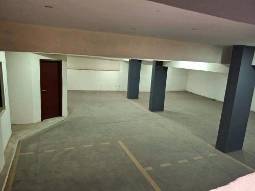an empty room with blue columns and a door at Lagos Luxury Residence Opebi in Ikeja