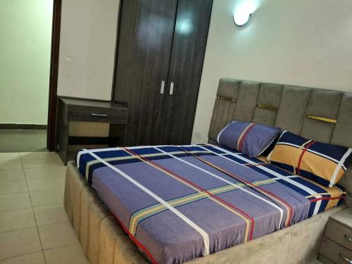 a bedroom with a large bed with a wooden headboard at Lagos Luxury Residence Opebi in Ikeja