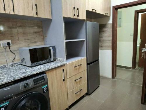 a kitchen with a refrigerator and a microwave at Lagos Luxury Residence Opebi in Ikeja
