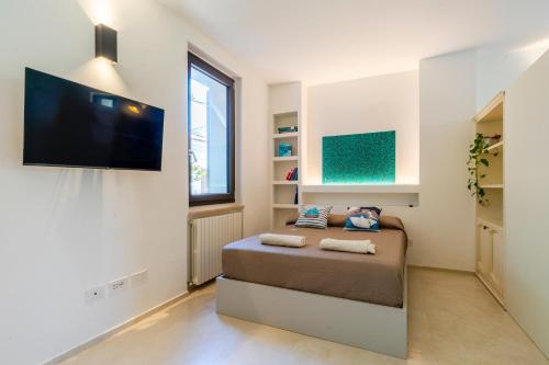 a bedroom with a bed and a flat screen tv at Magnolia house- monolocale con ingresso indipendente in Civitanova Marche