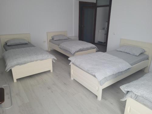 a group of three beds in a room at Vila Vati - Arena Pitesti in Piteşti