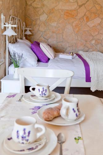 a bedroom with a bed and two tea cups and pastries at Barackvirág Apartmanház in Tihany