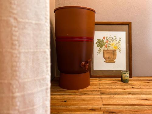 a coffee cup sitting on a floor next to a picture at Sítio Passarim in São Francisco Xavier