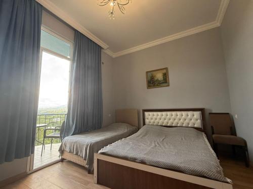 a bedroom with a bed and a large window at Petra Tsikhisdziri in Ts'ikhisdziri
