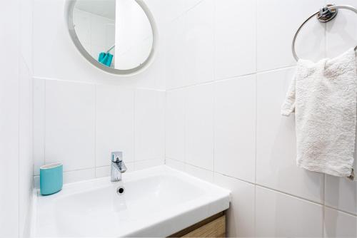 une salle de bain blanche avec un lavabo et un miroir dans l'établissement Charming Room Center of Paris, à Paris
