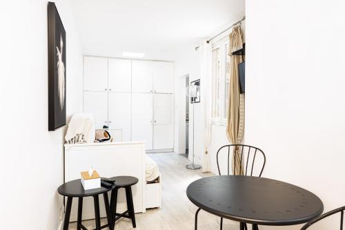 - un salon blanc avec une table et des chaises noires dans l'établissement Charming Room Center of Paris, à Paris