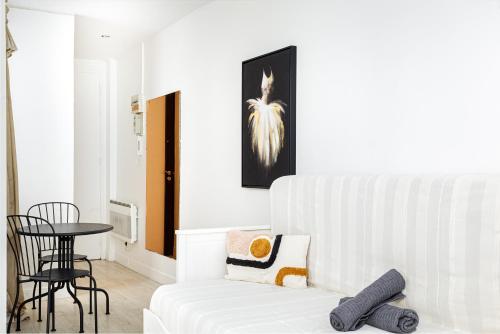 un salon avec un canapé blanc et une table dans l'établissement Charming Room Center of Paris, à Paris