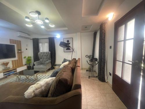 a living room with a couch and a tv at Luxury apt,Secure estate,Parking,10mins to Airport in Hausa